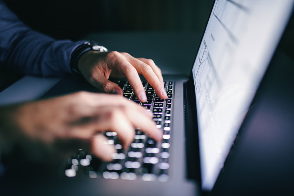 En person skriver på en laptop