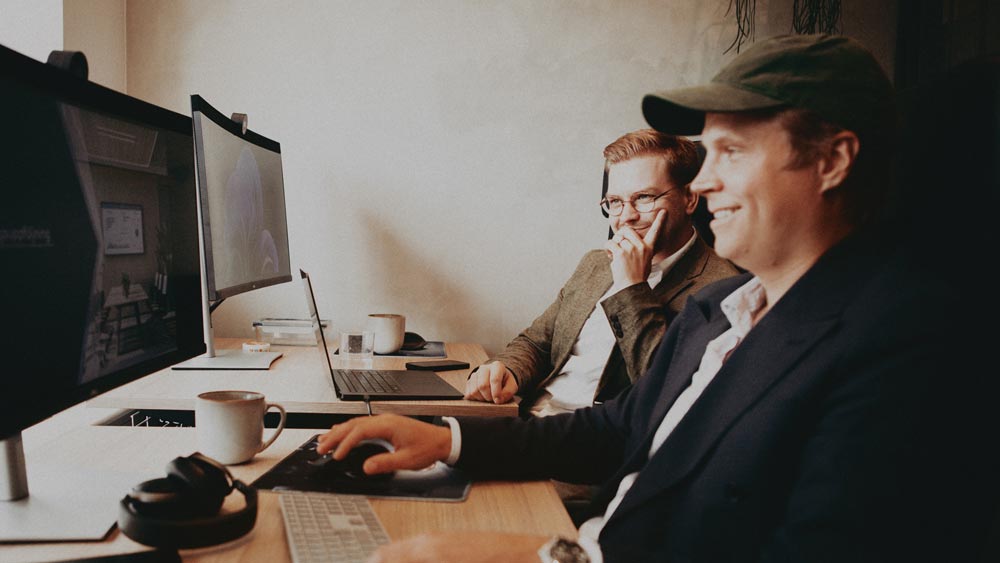 Två kollegor sitter framför sina datorer